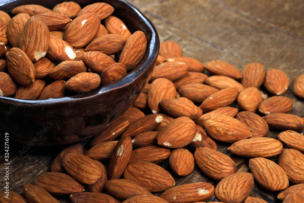 Wall mural bowl with shelled almond on wooden table