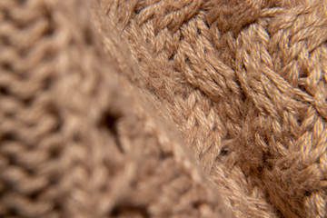 detail of embroidered wool sweater, braided in cream or camel, fabric detail