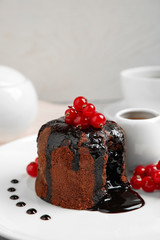 Fototapeta na wymiar Delicious warm chocolate lava cake with berries on plate, closeup