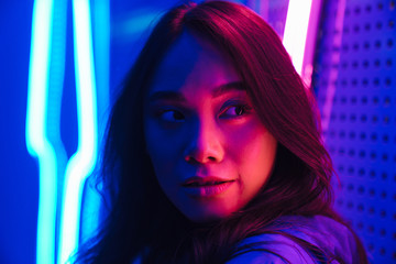 Beautiful young woman posing over neon lights.