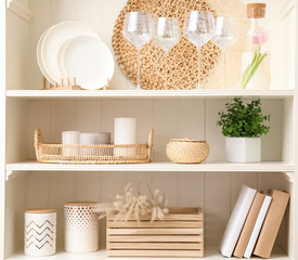 White shelving unit with dishware and different decorative stuff
