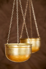 Business balance concept, gold weighing scales on brown background