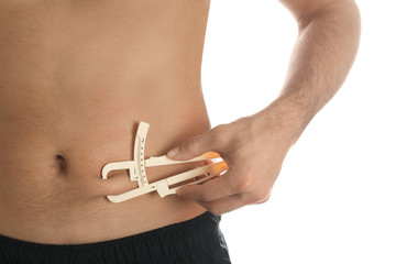 Man measuring body fat layer with caliper on white background, closeup. Nutritionist's tool