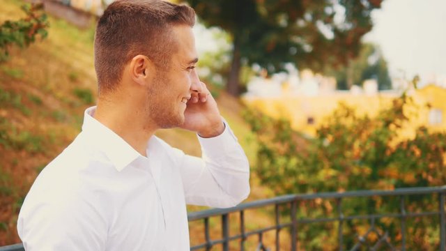 Successful, confident business man is on the phone, isolated, street background. Close up. Copy space. 4K.