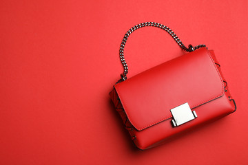 Stylish woman's bag on red background, top view. Space for text - obrazy, fototapety, plakaty