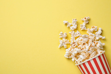 Delicious popcorn on yellow background, top view. Space for text