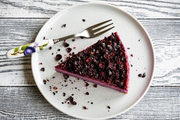 Cake with black currants and nuts on a white wooden background. Raw dessert. Tasty and healthy....