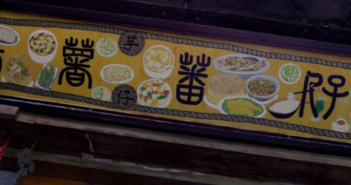 Chinese character typeface lettering & photos of various foods on plastic banner.