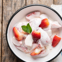 Strawberries and cream dessert on wooden background