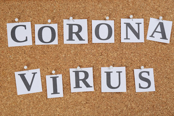 Words CORONA VIRUS pinned to corkboard, top view