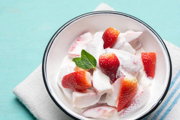 Strawberries and cream dessert on turquoise background