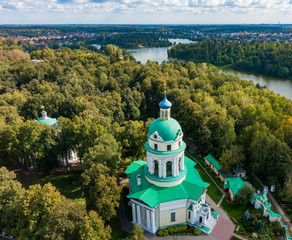 Orthodox church in Grebnevo in the forest by the river, aerial photo