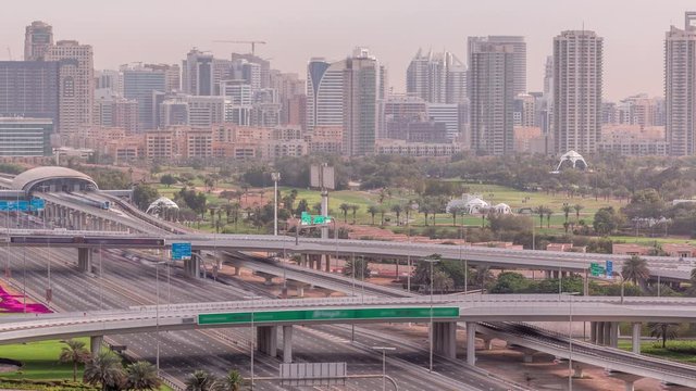 Dubai Golf Course with a cityscape of Gereens and tecom districts at the background aerial timelapse. Traffic on sheikh zayed road with junction and bridges