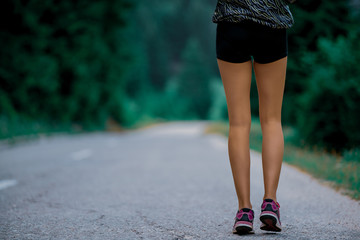 young fitness woman running at forest trail