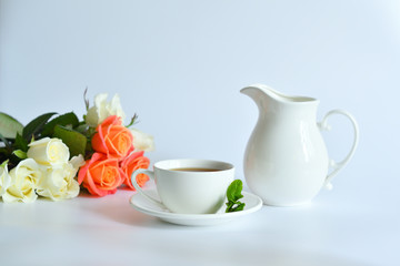 One small cup of tea with mint and jug on white background.