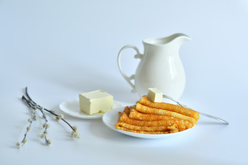 Pancake week: thin pancakes with butter and tea on white table.french crepes .thin pancakes and glass of milk on the table.Delicious breakfast.Selective focus