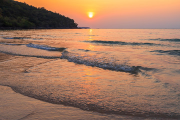 Beautiful early sunset over and Wave of the sea on the sand beach the horizon Summer time at hat sai kaew beach in Chanthaburi Thailand.