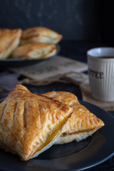 Fresh baked puff pastry buns with spinach on a grey background
