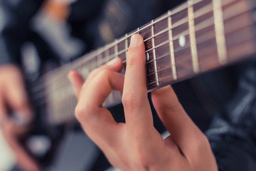Close-up of man playing electric guitar.