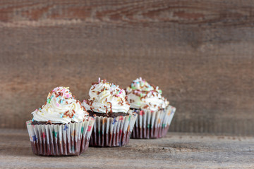 Delicious homemade cupcakes on a wooden table and background. Holiday food