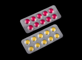 two packages of red and yellow medicine on a black background