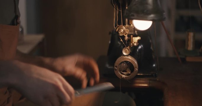 Traditional bespoke shoemaker stop stitching sewing leather upper checking old sewing machine close up