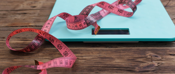 blue floor scales and pink tape on dark wooden background