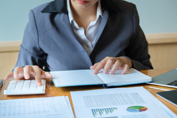 The financial concept of an auditor. A businessman works on calculator to calculate finance of company in her office.