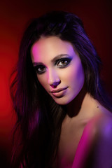 Fototapeta premium Colorful portrait of an attractive young woman under red background