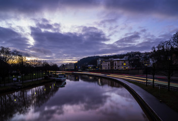 Germany, Saarbruecken city highway traffic and silent water of saar river in violet early morning...