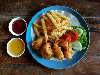 Fried shrimp with french fries and salad, top view