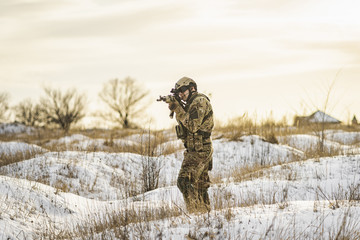 equipped army soldier Man in the winter khaki camouflage is patrolling or patrol field territory....