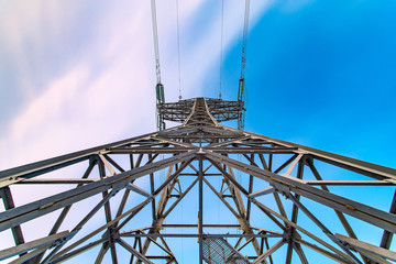 Symmetric view of power pylons against a beautiful coloured evening sky. Bottom view.