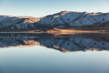 Obraz premium Mirror reflection in calm lake. morning light. Western Mongolia