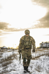 equipped army soldier Man in the winter khaki camouflage is patrolling or patrol field territory....