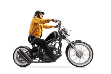 Fototapeta na wymiar Elderly man in a yellow leather jacket riding a black custom motorbike