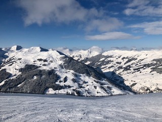 Obraz premium Empty snowy skiing slope in the mountains with blue cloudy sky