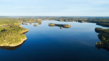 Blue lakes, islands and green forests from above on a summer evening. Aerial view of beautiful National park Kolovesi in Finland. 