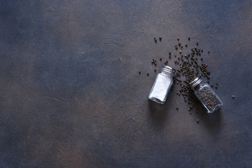 Salt and pepper peas in a glass jar on a concrete dark background. Food background- spices, top...