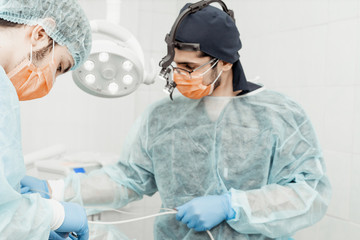 Naklejka premium Dentists will perform an operation, implant placement. Real operation. Tooth extraction, implants. Professional uniform and equipment of a dentist. Healthcare Equipping a doctor’s workplace. Dentistry