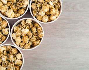 many red cardboard cup with sugar popcorn on a wooden table