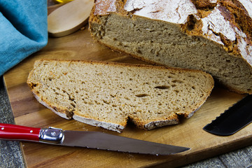 Close up of fresh made german stoneoven bread, cut slice and brown white loaf with crunchy crust on...