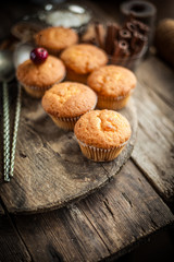 Muffins - sweet homemade cakes on a wooden kitchen table.