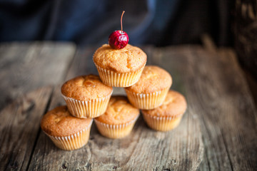 Muffins - sweet homemade cakes on a wooden kitchen table.