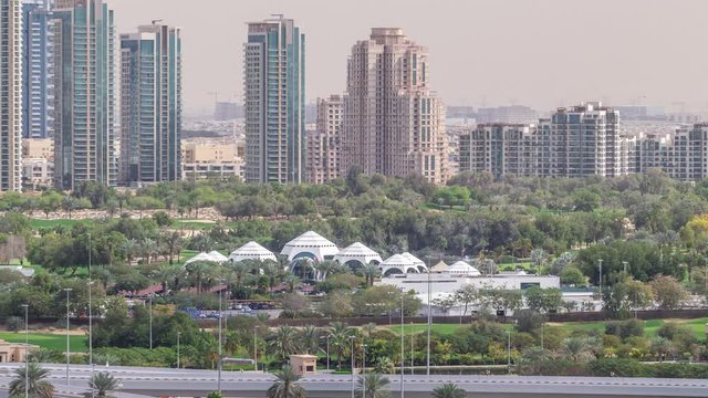 Dubai Golf Course with a cityscape of Gereens and tecom districts at the background aerial timelapse. Traffic on sheikh zayed road with junction
