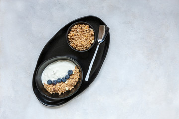Homemade Ready breakfast granola, muesli with fresh ripe blueberry, white chocolate and natural yogurt. Close-up, useful product, background.