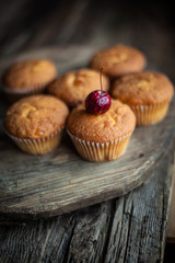 Muffins - sweet homemade cakes on a wooden kitchen table.