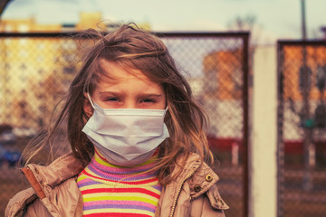 a girl with white hair and a mask on her face looks at us. Close-up.