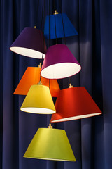Shade lamps multicolor on dark curtains background.