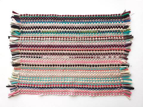 Traditional and colorful ethnic table-cloth isolated over white background. Mexican handmade tablecloth with fringes.